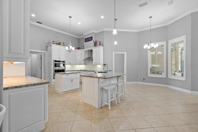 8815 SW 11th Ave, Gainesville, FL 32607 - kitchen with visible vents, a high ceiling, wall chimney exhaust hood, a chandelier, and stainless steel appliances