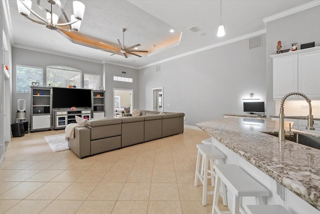 8815 SW 11th Ave, Gainesville, FL 32607 - living room with crown molding, a raised ceiling, ceiling fan with notable chandelier, and light tile patterned floors