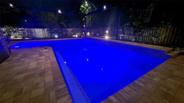 8815 SW 11th Ave, Gainesville, FL 32607 - pool at night with a fenced in pool, a fenced backyard, and a patio area