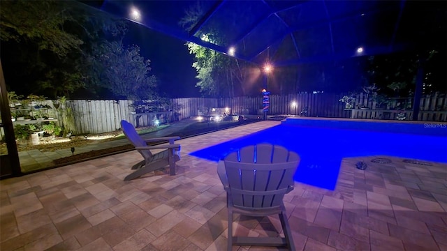 8815 SW 11th Ave, Gainesville, FL 32607 - pool at night with a fenced in pool, a fenced backyard, and a patio