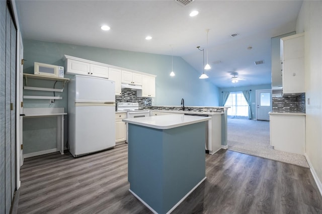 6355 NW 106th Pl, Alachua, FL 32615 - kitchen with backsplash, vaulted ceiling, a peninsula, under cabinet range hood, and white appliances