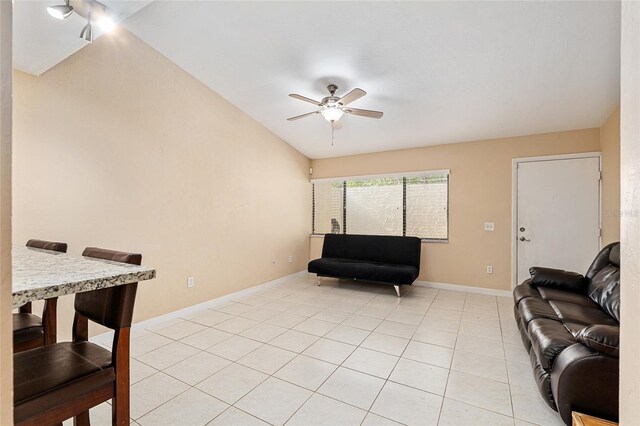 living room with a ceiling fan, baseboards, and light tile patterned floors