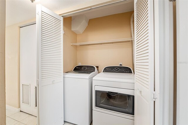 washroom featuring washing machine and clothes dryer, laundry area, and light tile patterned floors