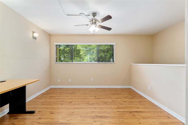 unfurnished room featuring baseboards, a ceiling fan, and light wood-style flooring