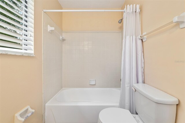 bathroom featuring toilet and shower / bath combo with shower curtain
