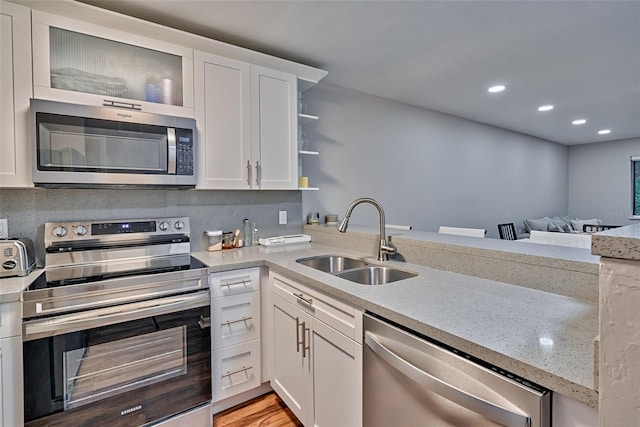 105 SE 16th Ave Unit N103, Gainesville, FL 32601 - kitchen with stainless steel appliances, white cabinets, recessed lighting, light stone counters, and open shelves