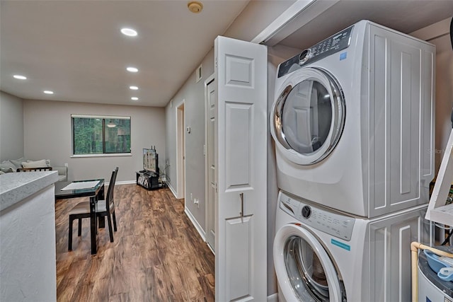 105 SE 16th Ave Unit N103, Gainesville, FL 32601 - laundry area featuring stacked washer / dryer, wood finished floors, and recessed lighting