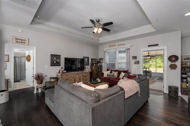 living room featuring a ceiling fan, a textured ceiling, crown molding, a raised ceiling, and dark wood-style floors