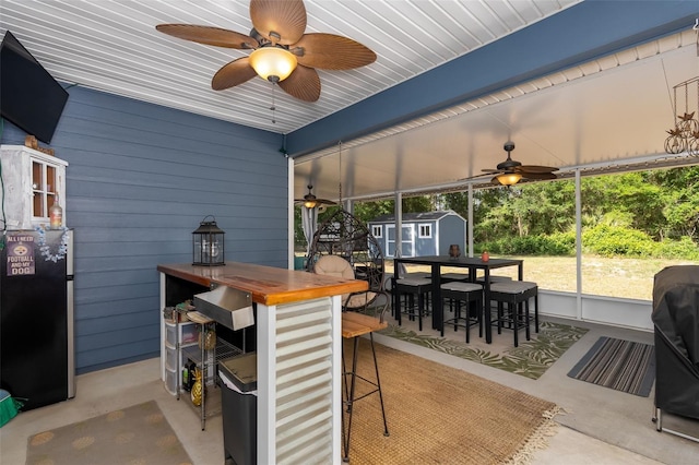 exterior space with an outdoor structure, ceiling fan, a shed, and outdoor dry bar