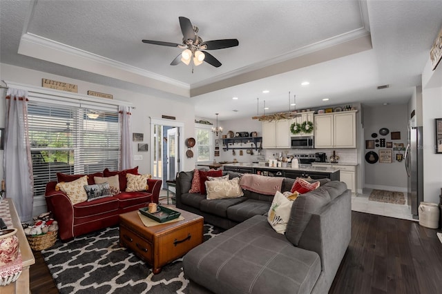 living area with crown molding, dark wood-style flooring, ceiling fan, recessed lighting, and a tray ceiling