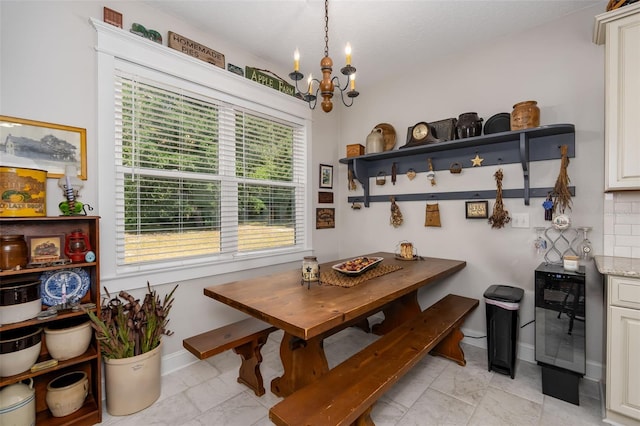 dining room featuring an inviting chandelier, marble finish floor, and baseboards