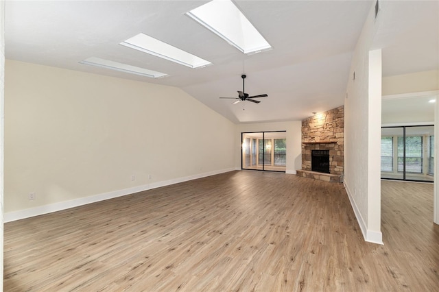 1612 NW 19th Cir, Gainesville, FL 32605 - unfurnished living room with a stone fireplace, ceiling fan, a healthy amount of sunlight, and light wood-style flooring