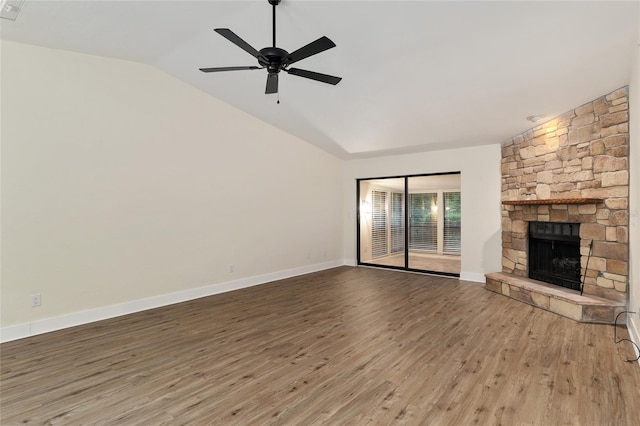 1612 NW 19th Cir, Gainesville, FL 32605 - unfurnished living room featuring a stone fireplace, a ceiling fan, baseboards, wood finished floors, and vaulted ceiling