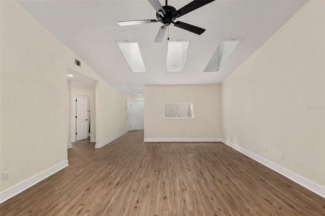 1612 NW 19th Cir, Gainesville, FL 32605 - unfurnished living room featuring a ceiling fan, visible vents, a skylight, wood finished floors, and baseboards