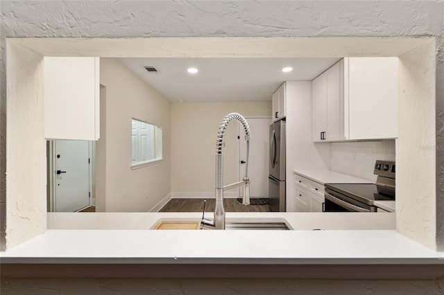 1612 NW 19th Cir, Gainesville, FL 32605 - kitchen with baseboards, recessed lighting, white cabinetry, a sink, and stainless steel appliances