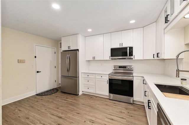 1612 NW 19th Cir, Gainesville, FL 32605 - kitchen featuring a sink, white cabinetry, appliances with stainless steel finishes, and backsplash
