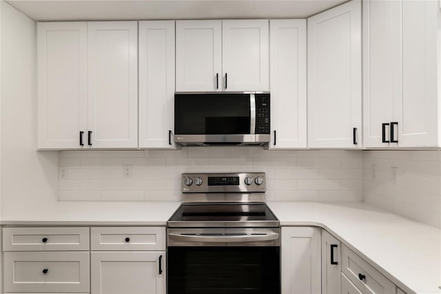 1612 NW 19th Cir, Gainesville, FL 32605 - kitchen featuring light countertops, white cabinets, backsplash, and stainless steel appliances