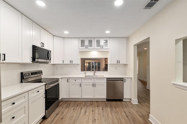 1612 NW 19th Cir, Gainesville, FL 32605 - kitchen with tasteful backsplash, a sink, white cabinets, stainless steel appliances, and recessed lighting