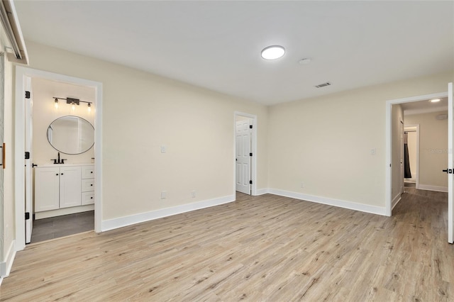 1612 NW 19th Cir, Gainesville, FL 32605 - unfurnished bedroom featuring baseboards, visible vents, ensuite bathroom, and light wood-style floors
