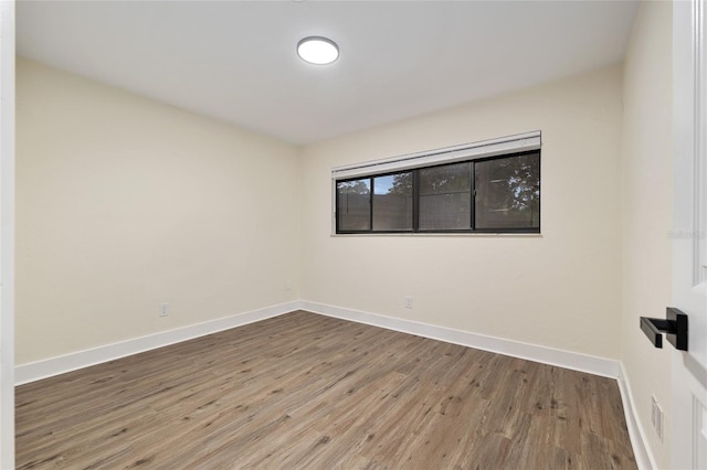 1612 NW 19th Cir, Gainesville, FL 32605 - unfurnished room with baseboards, visible vents, and wood finished floors
