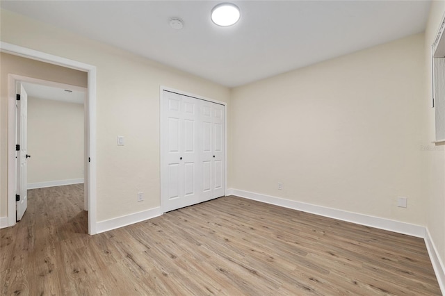 1612 NW 19th Cir, Gainesville, FL 32605 - unfurnished bedroom featuring baseboards, light wood finished floors, and a closet