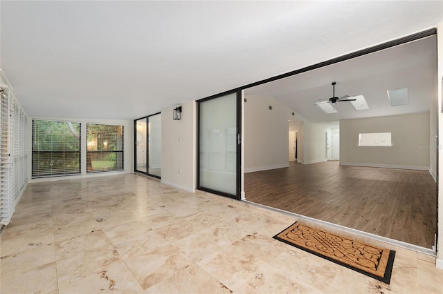 1612 NW 19th Cir, Gainesville, FL 32605 - empty room with expansive windows, ceiling fan, vaulted ceiling, and baseboards