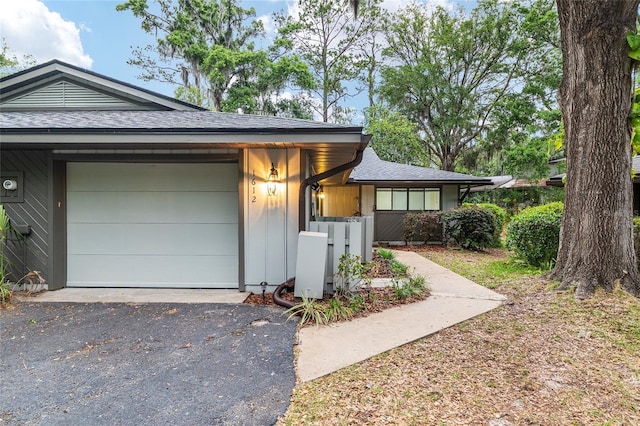 1612 NW 19th Cir, Gainesville, FL 32605 - view of front of home featuring a garage, a shingled roof, and aphalt driveway