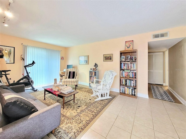 living area with light tile patterned floors and baseboards