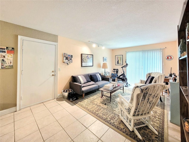 living room with rail lighting, light tile patterned floors, a textured ceiling, and baseboards