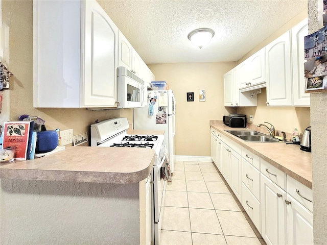 kitchen featuring white appliances, a sink, white cabinetry, a textured ceiling, and light tile patterned floors