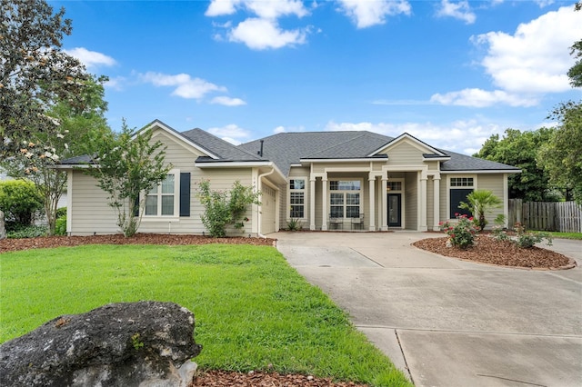 view of front facade with fence, a shingled roof, a garage, a front yard, and driveway