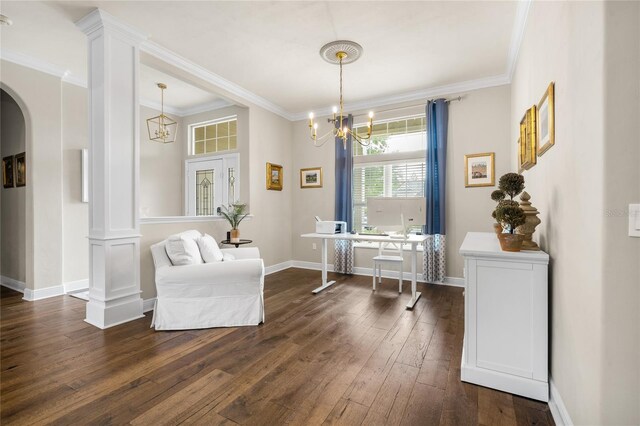 sitting room with dark wood-style flooring, crown molding, arched walkways, a notable chandelier, and ornate columns