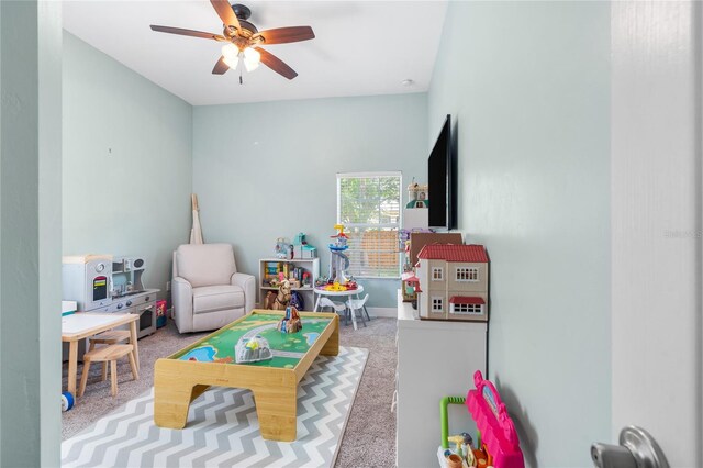 recreation room with a ceiling fan and carpet