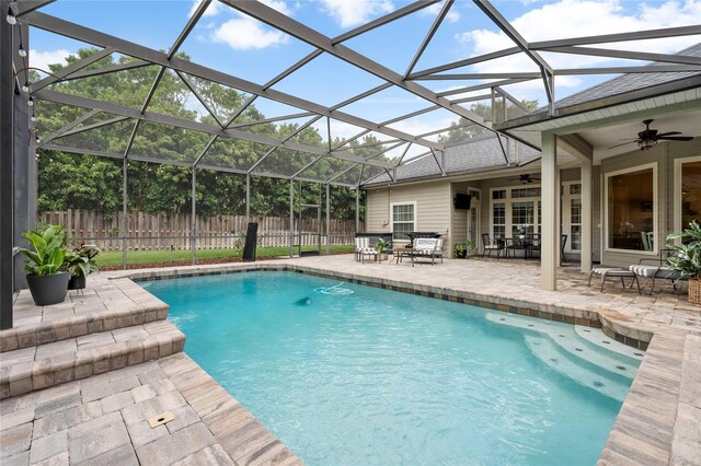view of pool with fence, a fenced in pool, a patio area, a ceiling fan, and glass enclosure