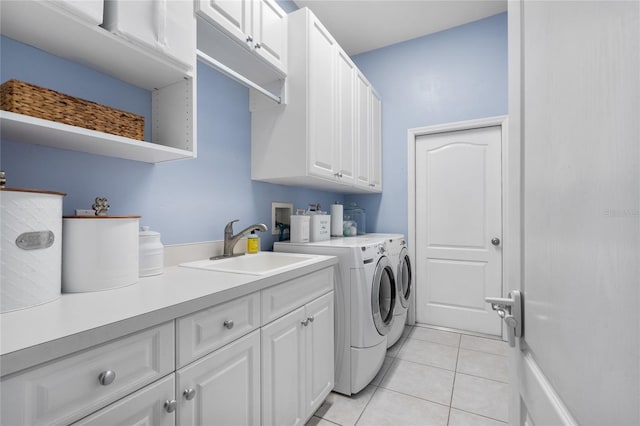 clothes washing area featuring cabinet space, separate washer and dryer, light tile patterned floors, and a sink