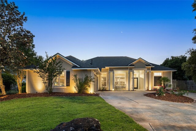 single story home featuring fence, roof with shingles, an attached garage, a front lawn, and driveway