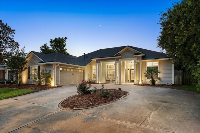single story home featuring roof with shingles, fence, an attached garage, and concrete driveway