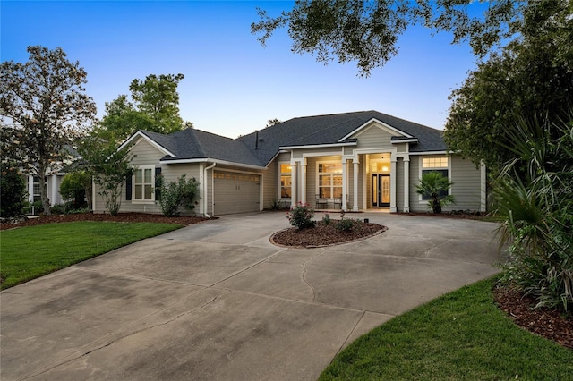 single story home featuring a garage, a shingled roof, a yard, and driveway