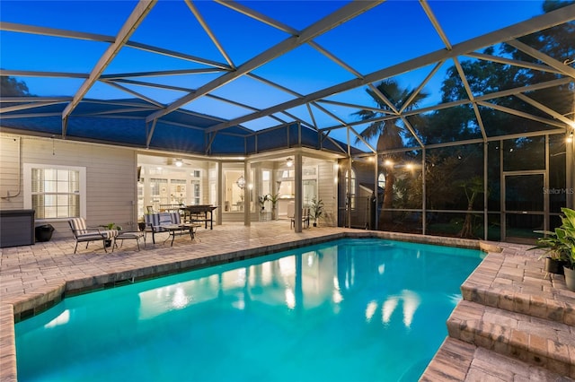 pool featuring ceiling fan, a patio area, and glass enclosure