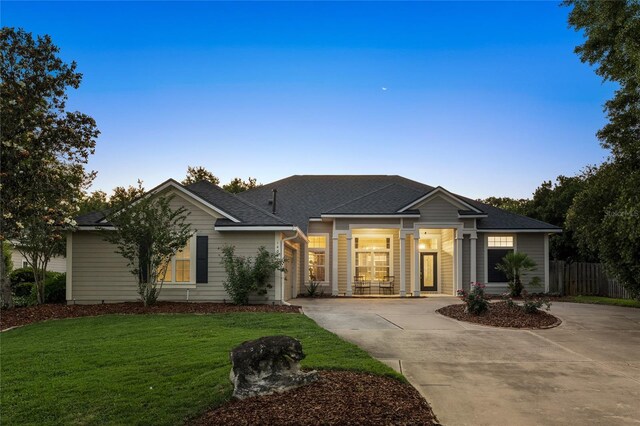 ranch-style home with fence, a yard, a shingled roof, and concrete driveway