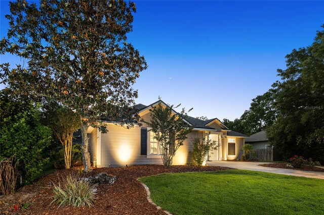 view of front of house with fence, driveway, and a front yard