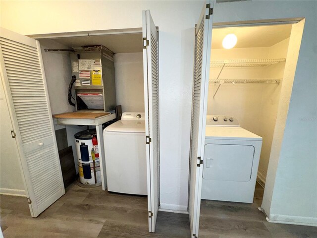laundry room featuring laundry area, washer and clothes dryer, baseboards, and wood finished floors