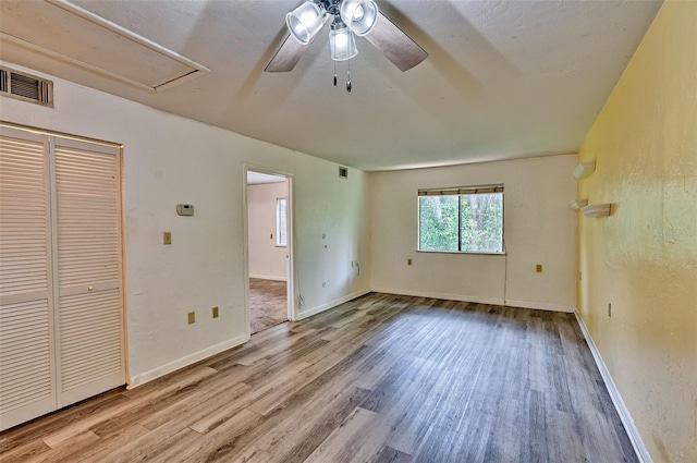 111 SE 16th Ave Unit O304, Gainesville, FL 32601 - unfurnished bedroom with attic access, wood finished floors, a ceiling fan, and a closet