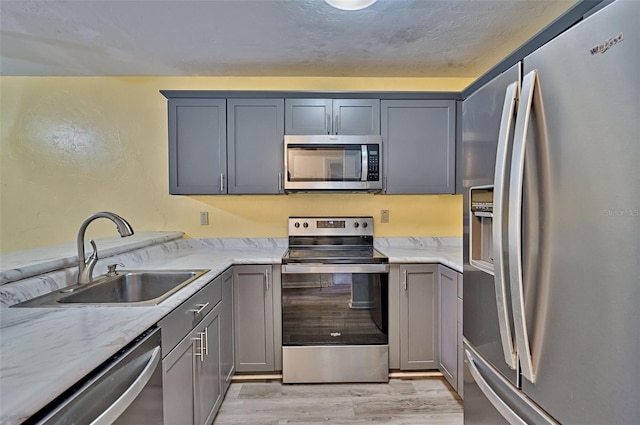 111 SE 16th Ave Unit O304, Gainesville, FL 32601 - kitchen featuring appliances with stainless steel finishes, gray cabinetry, and light wood-type flooring