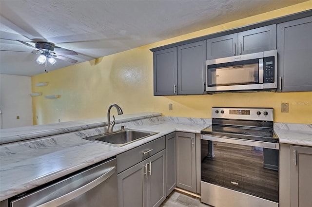 111 SE 16th Ave Unit O304, Gainesville, FL 32601 - kitchen with stainless steel appliances, gray cabinets, a ceiling fan, and light wood-style flooring