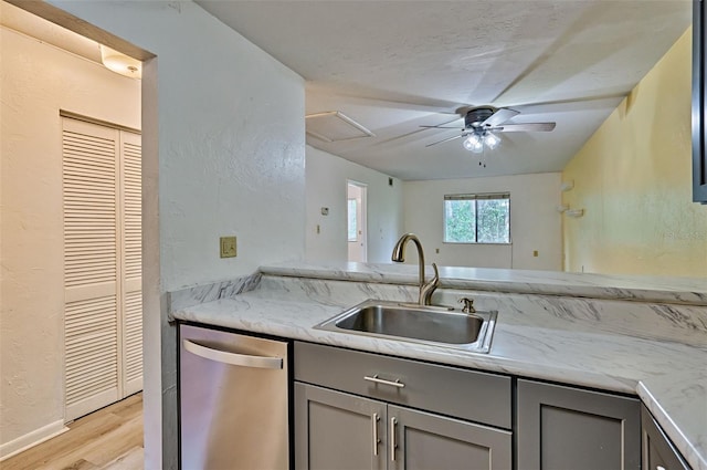 111 SE 16th Ave Unit O304, Gainesville, FL 32601 - kitchen with stainless steel dishwasher, gray cabinetry, light wood-style floors, a textured wall, and a ceiling fan