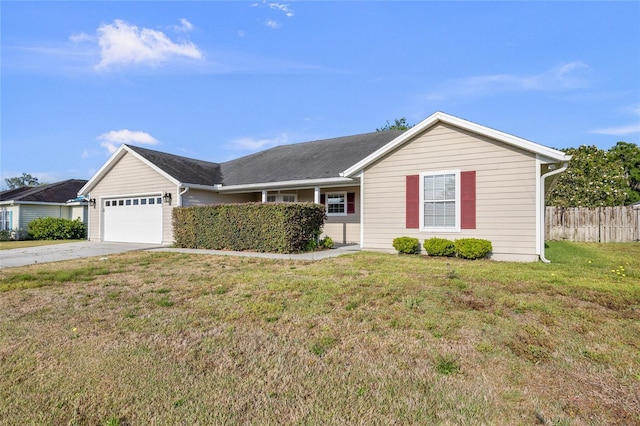 ranch-style home featuring an attached garage, fence, driveway, and a front yard