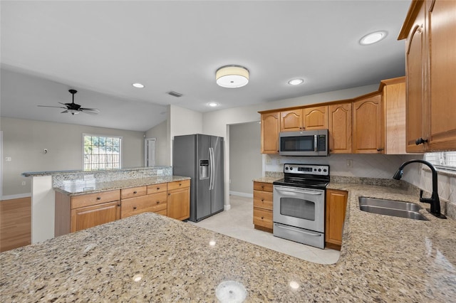 kitchen with visible vents, a peninsula, baseboards, a sink, and stainless steel appliances