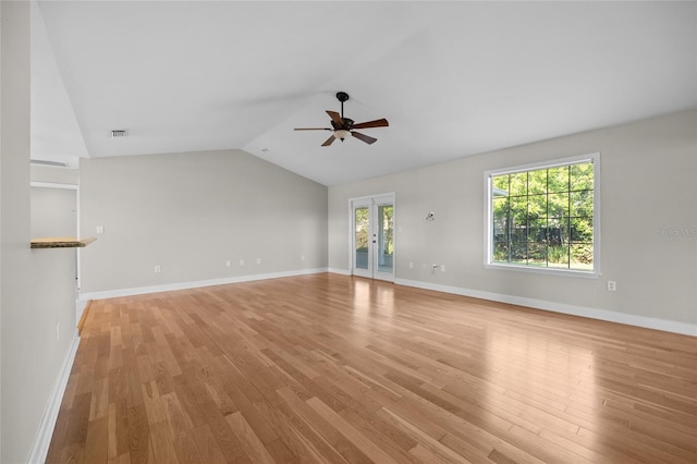 unfurnished living room with a ceiling fan, french doors, vaulted ceiling, baseboards, and light wood-style flooring