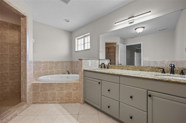 bathroom with tile patterned floors, a tile shower, a sink, and a bath